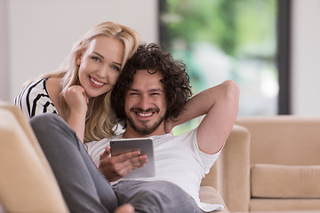 Image showing couple relaxing at  home with tablet computers