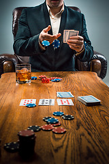 Image showing The man, chips for gamblings, drink and playing cards