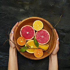 Image showing Grapefruit citrus fruit halves on wooden plate