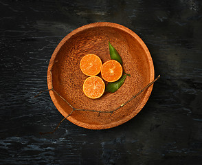 Image showing The oranges citrus fruit halves on wooden plate