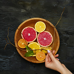 Image showing Grapefruit citrus fruit halves on wooden plate