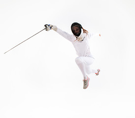 Image showing Man wearing fencing suit practicing with sword against gray