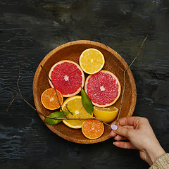 Image showing Grapefruit citrus fruit halves on wooden plate