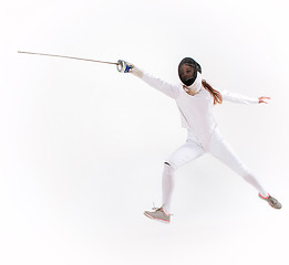 Image showing Man wearing fencing suit practicing with sword against gray