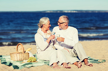 Image showing happy senior couple having picnic on summer beach