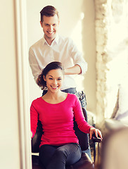 Image showing happy woman with stylist making hairdo at salon