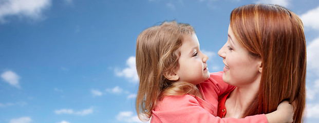 Image showing happy mother and daughter hugging over blue sky