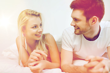 Image showing happy couple lying in bed at home