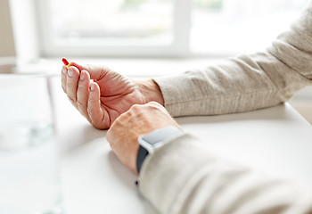 Image showing close up of old man hands with pill