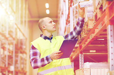 Image showing man with clipboard in safety vest at warehouse