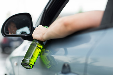 Image showing close up of man drinking alcohol while driving car