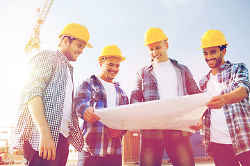 Image showing group of builders with tablet pc and blueprint