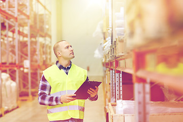 Image showing man with clipboard in safety vest at warehouse