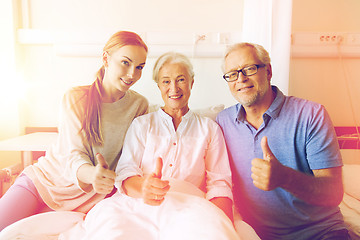 Image showing happy family visiting senior woman at hospital