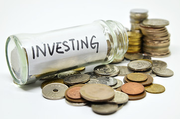 Image showing Investment lable in a glass jar with coins spilling out