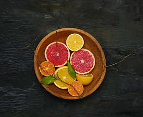 Image showing Grapefruit citrus fruit halves on wooden plate