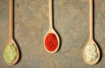 Image showing different types of sauces in spoons 