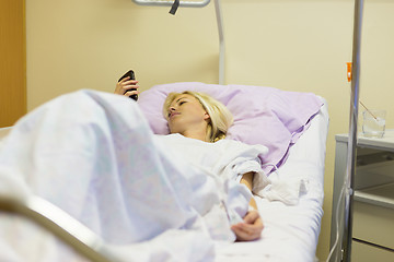 Image showing Bedridden female patient recovering after surgery in hospital care.