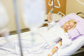 Image showing Bedridden female patient recovering after surgery in hospital care.