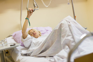 Image showing Bedridden female patient recovering after surgery in hospital care.