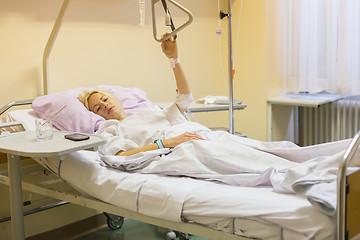 Image showing Bedridden female patient recovering after surgery in hospital care.