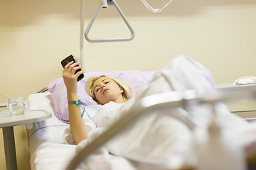 Image showing Bedridden female patient recovering after surgery in hospital care.