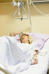 Image showing Bedridden female patient recovering after surgery in hospital care.