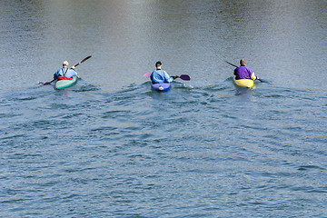 Image showing Three rowers with canoe recreate in a lake
