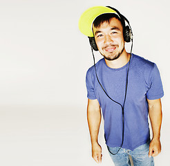 Image showing young asian man in hat and headphones listening music on white b