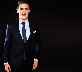 Image showing young pretty business man standing on black background, modern h