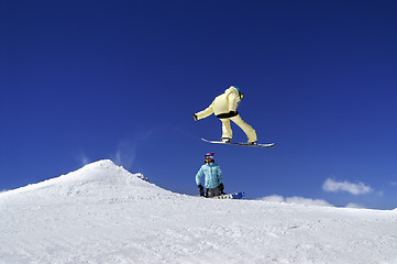 Image showing Two snowboarders in terrain park at ski resort on sun winter day