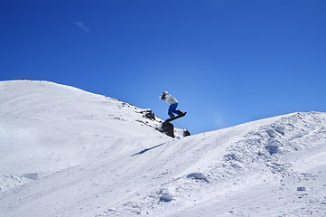 Image showing Snowboarder jumping in terrain park at ski resort on sun winter 