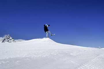 Image showing Snowboarder jump in terrain park at ski resort on sun winter day