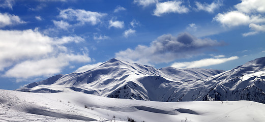 Image showing Panoramic view on ski slope and beautiful sky with clouds in sun