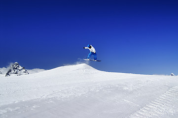 Image showing Snowboarder jump in snow park at ski resort on sunny winter day