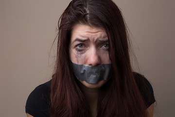 Image showing Frightened brunette hostage with tape