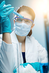 Image showing Lab technician experiments with reagents