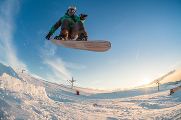 Image showing Snowboarder jumping against blue sky