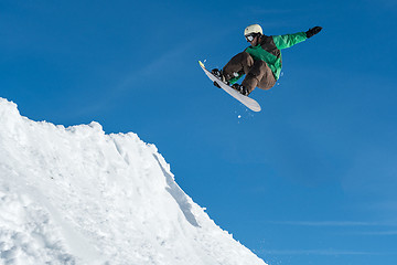 Image showing Snowboarder jumping against blue sky