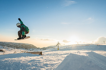 Image showing Snowboarder jumping against blue sky