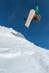 Image showing Snowboarder jumping against blue sky