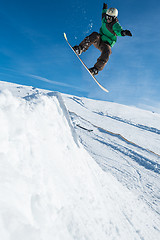 Image showing Snowboarder jumping against blue sky