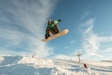 Image showing Snowboarder jumping against blue sky