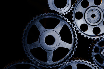 Image showing Interlocking industrial  cogwheels top view on black background