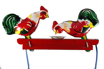 Image showing two chickens peck grain from a plate, toy