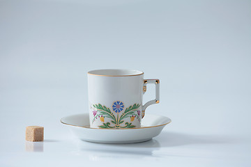 Image showing  Beautiful cup with flower and piece of sugar