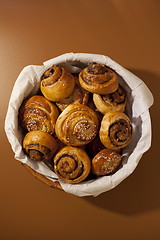 Image showing Full basket of sweet bread rolls with cinnamon and sesame seeds 