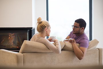 Image showing Young multiethnic couple  in front of fireplace