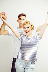 Image showing young pretty teenage couple, hipster guy with his girlfriend happy smiling and hugging isolated on white background, lifestyle people concept