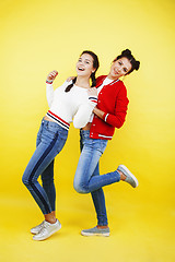 Image showing lifestyle people concept: two pretty school girl having fun on yellow background, happy smiling students 